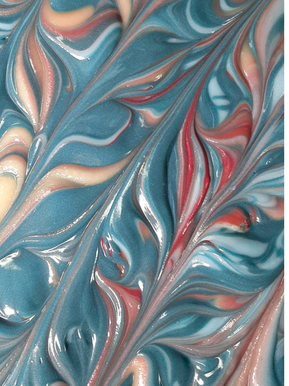 A close-up of a colorful Eucalyptus and Mint soap top  with swirling blue, pink, white, and beige patterns.