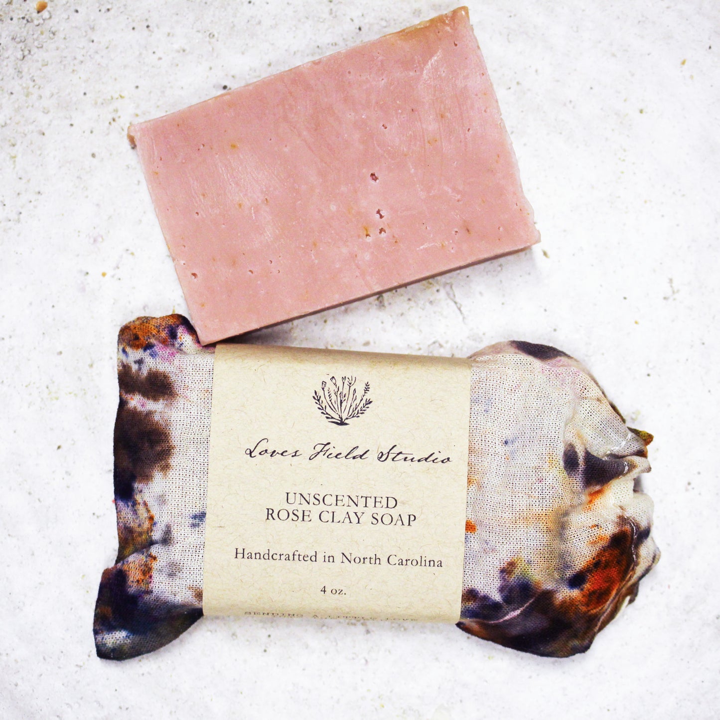 unscented goat milk soap bar with rose clay and calendula petals in hand dyed cotton gift bag